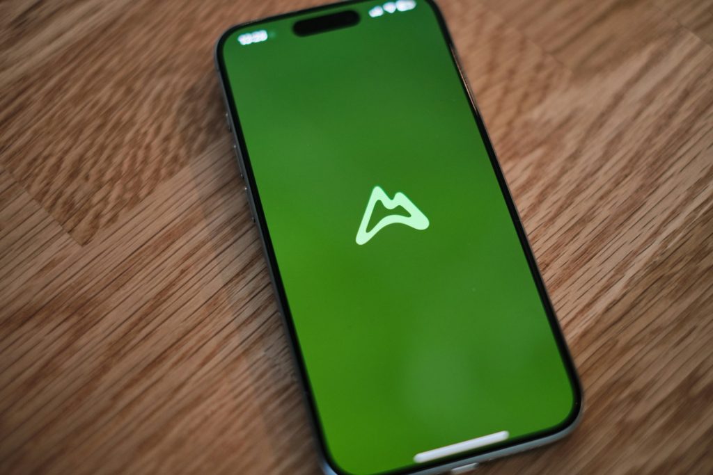 A green phone sitting on top of a wooden table